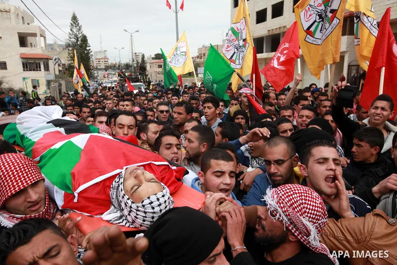 Palestinian mourners carry the body of 19-year old Palestinian Jihad al-Jaafari, who was shot dead on the roof of his house after Israeli soldiers entered the Dheishe refugee camp, near the West Bank city of Bethlehem be...