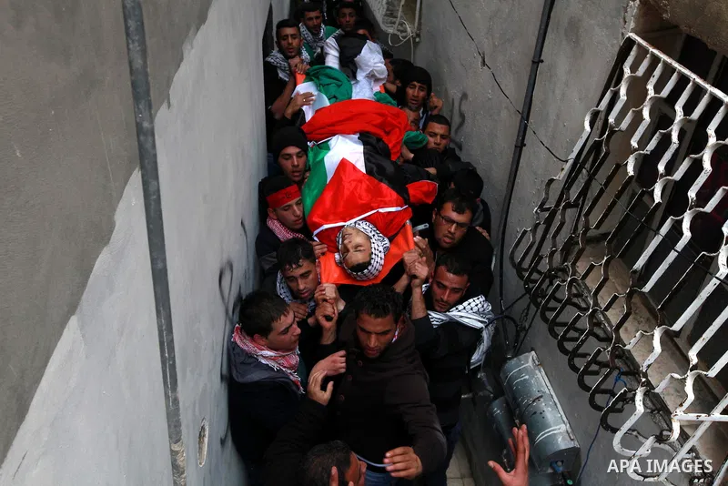 Palestinian mourners carry the body of 19-year old Palestinian Jihad al-Jaafari, who was shot dead on the roof of his house after Israeli soldiers entered the Dheishe refugee camp, near the West Bank city of Bethlehem be...
