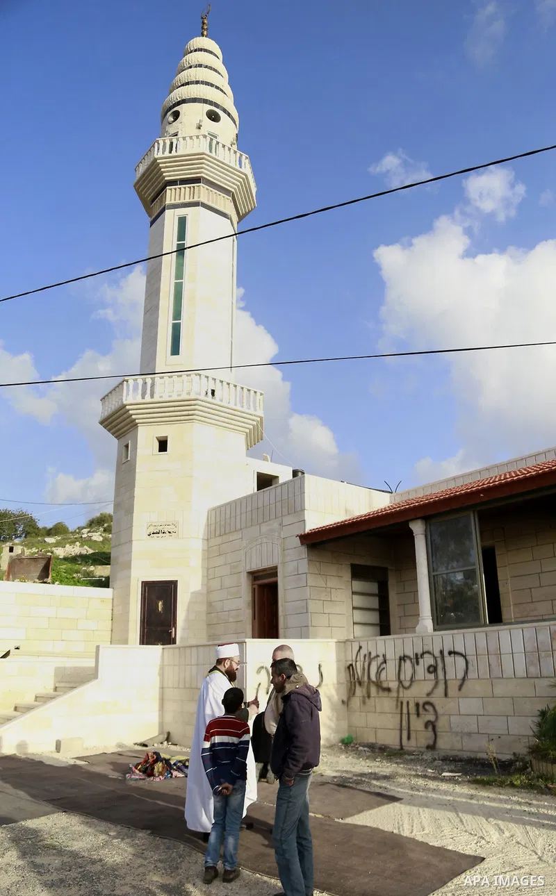 Palestinians inspect the burnt mosque in the West Bank village of Jab'a, near Bethlehem, just south of Jerusalem, in an apparent attack by Jewish settlers overnight on 25 February 2015. Hate graffiti was spray painted on...