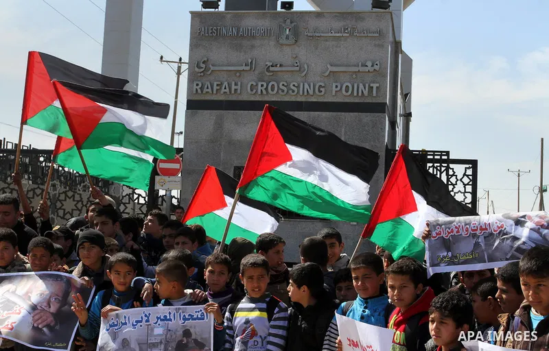 Palestinian students hold banners during a protest outside the Rafah crossing border, demanding the Egyptian authorities for the opening of the crossing, in Rafah in the southern Gaza Strip, February 26, 2015. Photo by A...