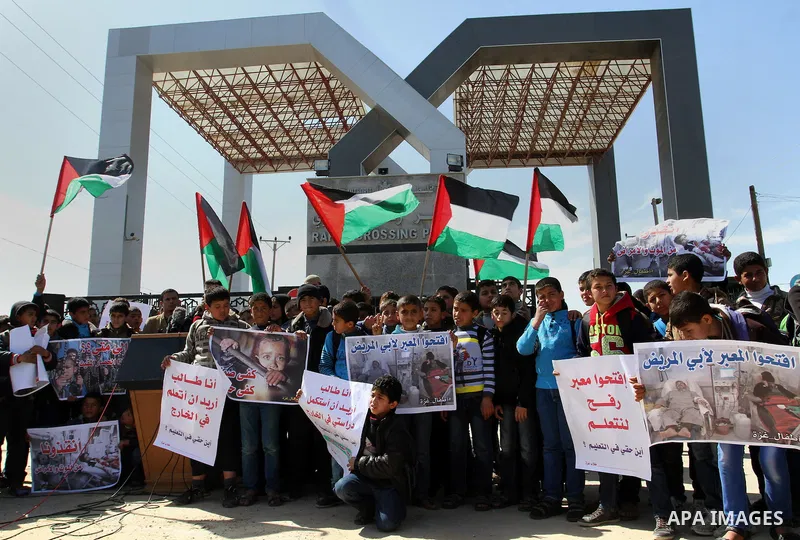 Palestinian students hold banners during a protest outside the Rafah crossing border, demanding the Egyptian authorities for the opening of the crossing, in Rafah in the southern Gaza Strip, February 26, 2015. Photo by A...