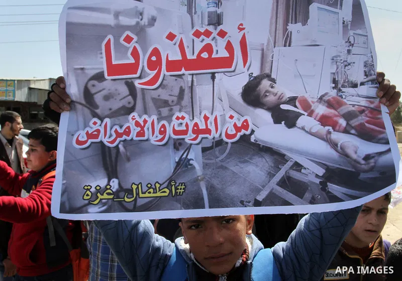 Palestinian students hold banners during a protest outside the Rafah crossing border, demanding the Egyptian authorities for the opening of the crossing, in Rafah in the southern Gaza Strip, February 26, 2015. Photo by A...