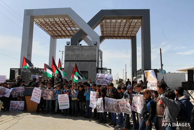 Palestinian students hold banners during a protest outside the Rafah crossing border, demanding the Egyptian authorities for the opening of the crossing, in Rafah in the southern Gaza Strip, February 26, 2015. Photo by A...