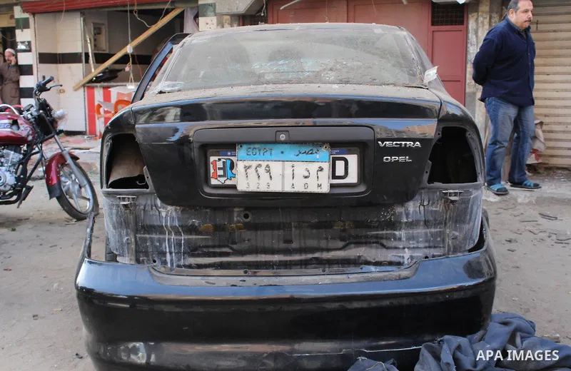Photo taken on Feb. 26, 2015 shows a damaged car near one of the blast site in front of a mobile shop in Cairo, Egypt. Six bombs detonated in the greater Cairo area in Egypt early on Thursday morning, killing one and inj...