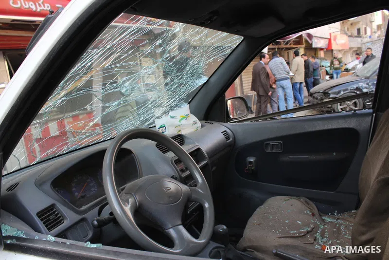 Photo taken on Feb. 26, 2015 shows a damaged car near one of the blast site in front of a mobile shop in Cairo, Egypt. Six bombs detonated in the greater Cairo area in Egypt early on Thursday morning, killing one and inj...