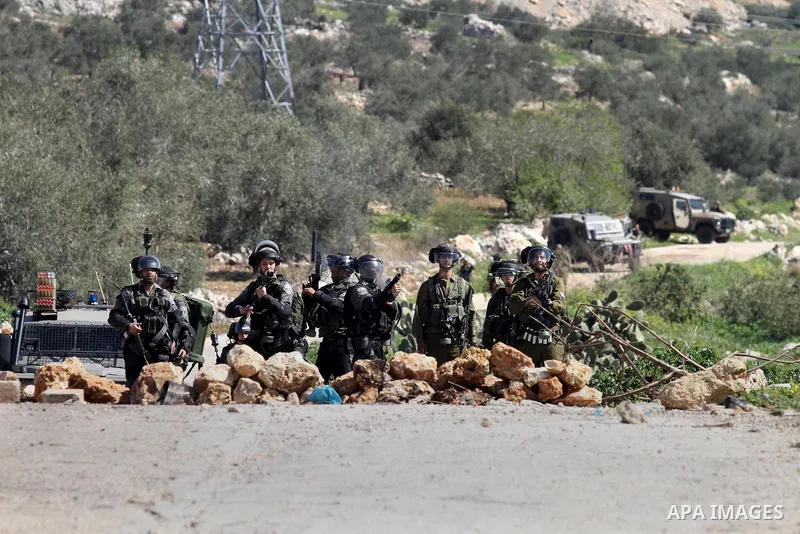 Israeli security forces fire tear gas towards Palestinian protester during clashes in the West Bank village of Azzun, following a protest against the closure of the main road in the village, near the West Bank city of Qa...