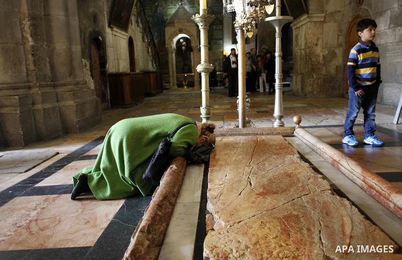 A christian pilgrim prays at the Church of the Holy Sepulchre in Jerusalem's Old city February 26, 2015. A fire damaged a Greek Orthodox seminary in Jerusalem on Thursday and "anti-Christian" graffiti was found at the sc...