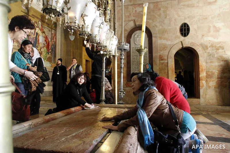 Christian pilgrims pray at the Church of the Holy Sepulchre in Jerusalem's Old city February 26, 2015. A fire damaged a Greek Orthodox seminary in Jerusalem on Thursday and "anti-Christian" graffiti was found at the scen...