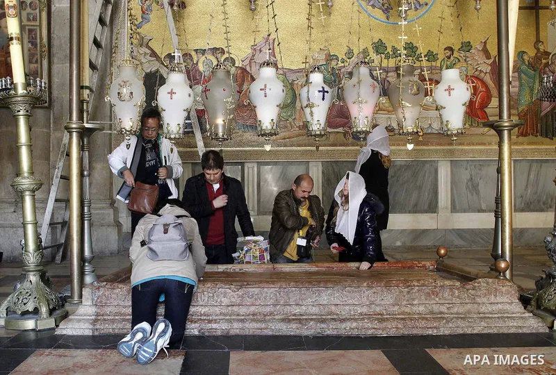 Christian pilgrims pray at the Church of the Holy Sepulchre in Jerusalem's Old city February 26, 2015. A fire damaged a Greek Orthodox seminary in Jerusalem on Thursday and "anti-Christian" graffiti was found at the scen...
