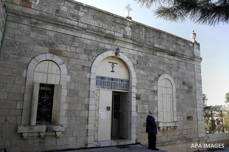 A Greek Orthodox priest stands outside a seminary in Jerusalem, Thursday Feb. 26, 2015. The Greek Orthodox seminary was damaged in fire and anti-Christian slogans were written in Hebrew, in what Israeli police said the s...