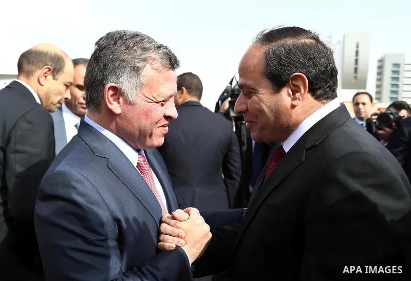 A handout picture released by the Egyptian Presidency shows Egyptian President Abdel Fattah al-Sisi (R) shaking hands with Jordan's King Abdullah II following the latter's arrival in Cairo for talks on the developments o...