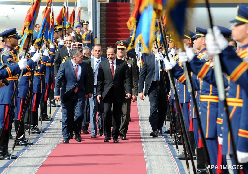 A handout picture released by the Egyptian Presidency shows Egyptian President Abdel Fattah al-Sisi (C-R) walking with Jordan's King Abdullah II following the latter's arrival in Cairo for talks on the developments of th...