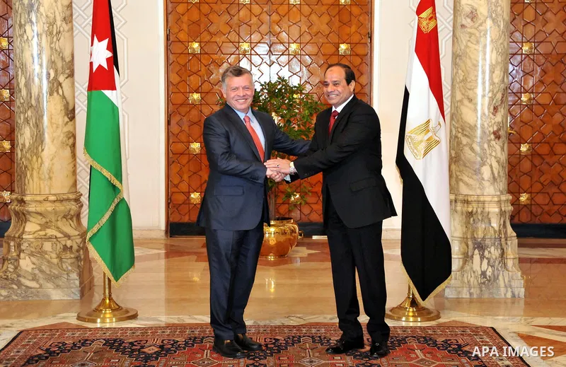 A handout picture released by the Egyptian Presidency shows Egyptian President Abdel Fattah al-Sisi (R) shaking hands with Jordan's King Abdullah II following the latter's arrival in Cairo for talks on the developments o...