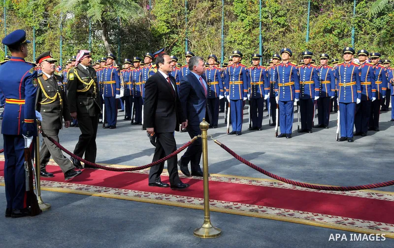 A handout picture released by the Egyptian Presidency shows Egyptian President Abdel Fattah al-Sisi (C-L) walking with Jordan's King Abdullah II following the latter's arrival in Cairo for talks on the developments of th...