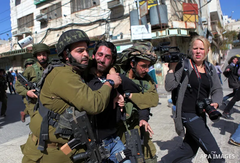 Israeli soldiers arrest a Palestinian demonstrator during a protest demanding the reopening of Shuhada Street in the West Bank city of Hebron on February 27, 2015. Photo by Mamoun Wazwaz