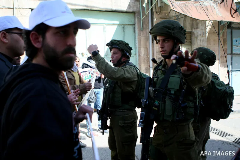 Israeli soldiers argue with Palestinian demonstrators during a protest demanding the reopening of Shuhada Street in the West Bank city of Hebron on February 27, 2015. Photo by Mamoun Wazwaz