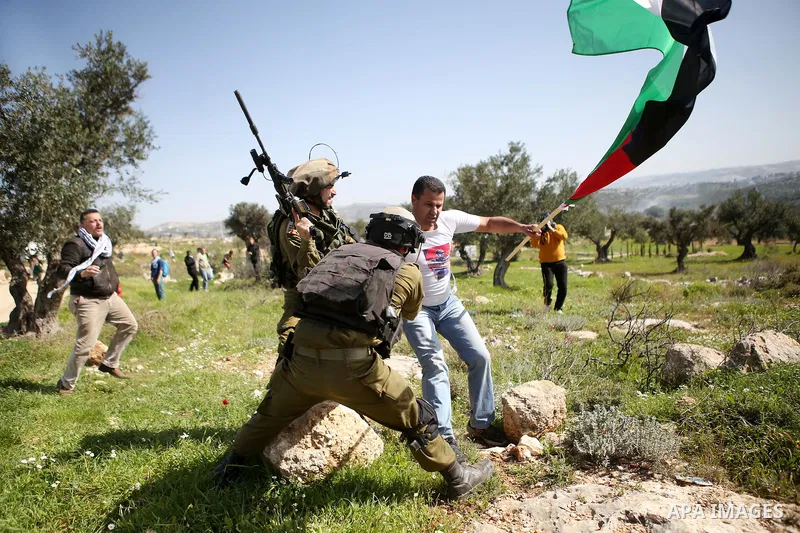 Israeli security forces detain a Palestinian protester during clashes following a demonstration against Jewish settlements in the West Bank village of Bilin, west of Ramallah, February 27, 2015. Photo by Shadi Hatem
