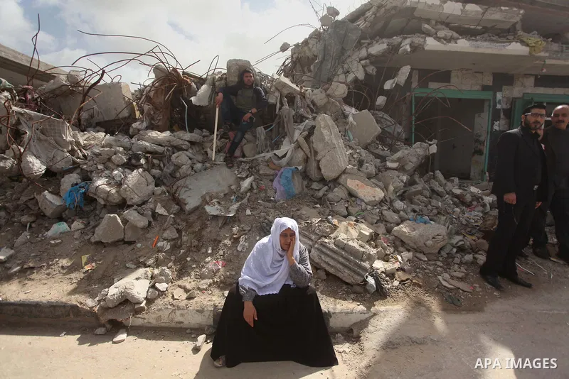 A Palestinian woman sits on the rubbles during a protest demanding for reconstruction of houses which were destroyed during the recent Israeli war, in Biet Hanoun in the northern Gaza Strip February 28, 2015. More than 1...