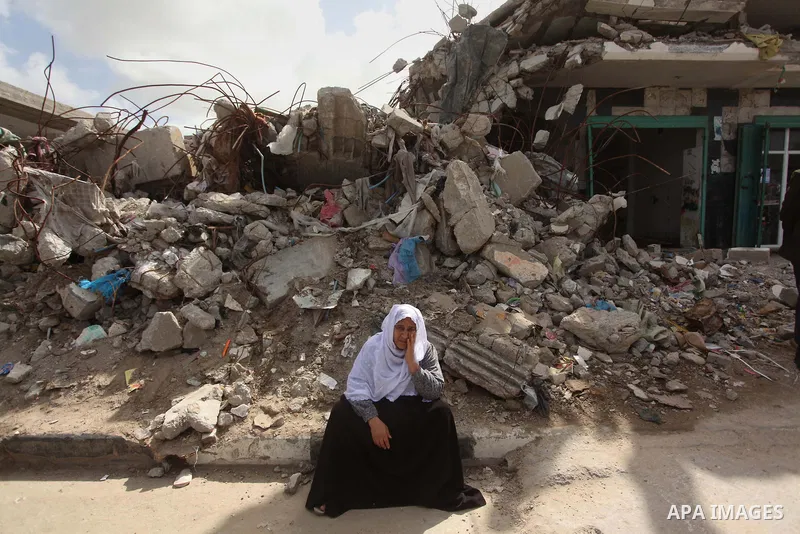 A Palestinian woman sits on the rubbles during a protest demanding for reconstruction of houses which were destroyed during the recent Israeli war, in Biet Hanoun in the northern Gaza Strip February 28, 2015. More than 1...