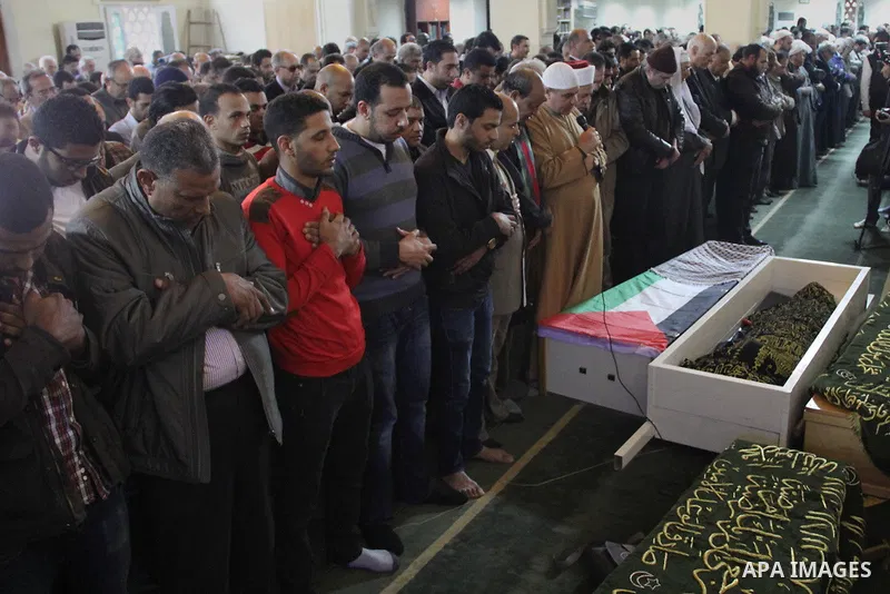 Egyptians pray on the body of Palestinian artist Ghassan Matar, 76, during his funeral, in cairo, Egypt on February 28, 2015. Photo by Amr Sayed