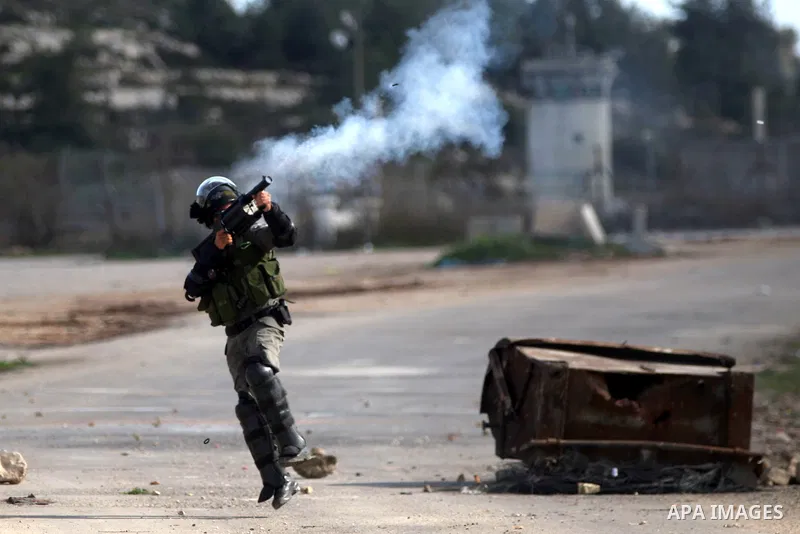 An Israeli border policeman fires a tear gas canister towards Palestinian stone-throwers during clashes following demonstration demanding the release of the prisoner Lena Khattab held in Israeli jails outside Israel's Of...