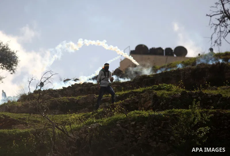 A Palestinian student of the BirZeit University throws a stone towards Israeli troops during clashes following a demonstration demanding the release of the prisoner Lena Khattab held in Israeli jails near Israel's Ofer m...