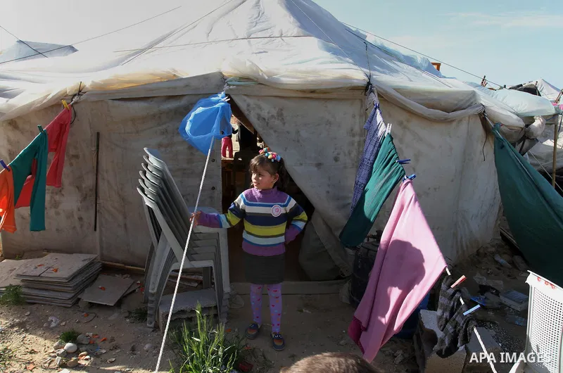 A Palestinian girl plays outside her a tent donated by a charity organisation as temporary housing for those whose houses were destroyed during a seven-week Israeli offensive, in Khuzaa, east of Khan Younis, in the south...