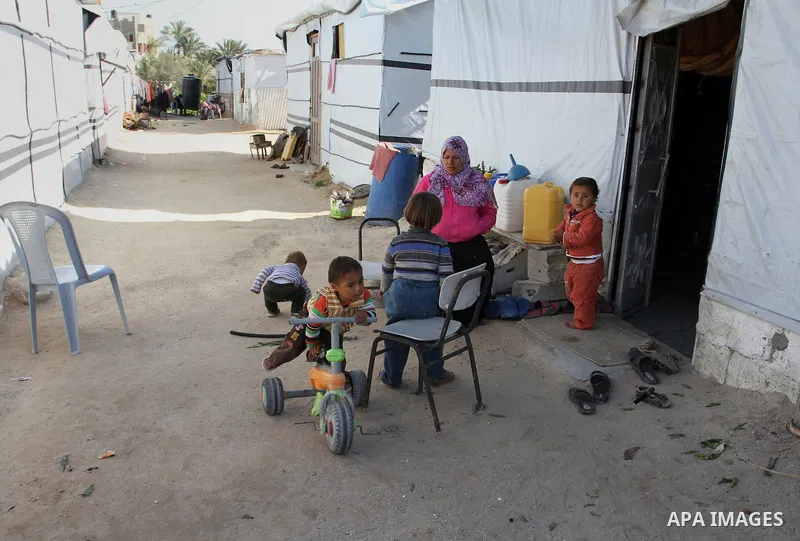 Palestinian children play outside their tents donated by a charity organisation as temporary housing for those whose houses were destroyed during a seven-week Israeli offensive, in Khuzaa, east of Khan Younis, in the sou...