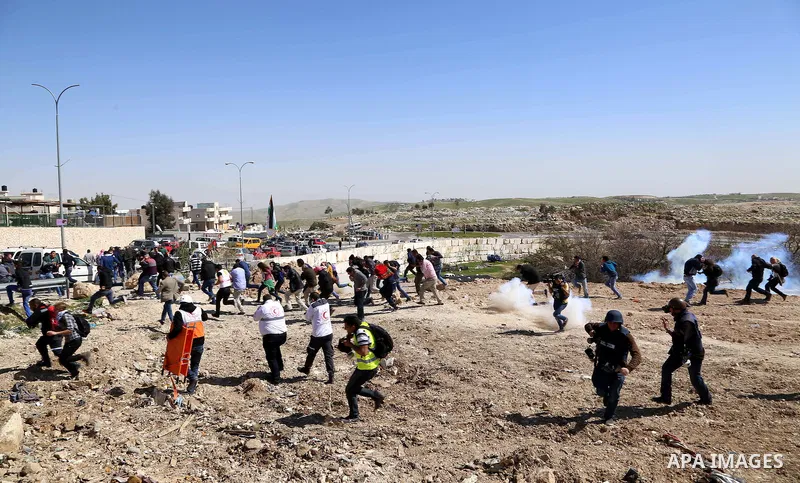 Palestinian protesters run away from tear gas fired by Israeli policemen as they clear a protest on land that Palestinians say was confiscated by Israel for Jewish settlements, near the West Bank town of Abu Dis near Jer...