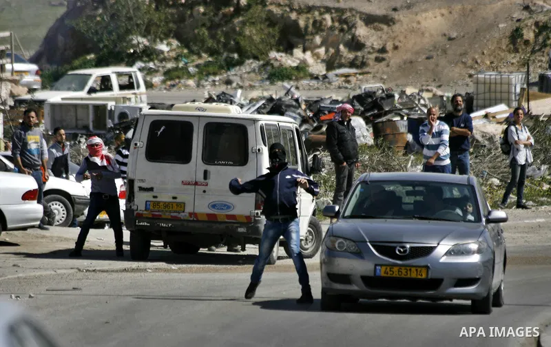 Palestinian protesters throw stones at Israeli border policemen during clashes after they clear a protest on land that Palestinians say was confiscated by Israel for Jewish settlements, near the West Bank town of Abu Dis...