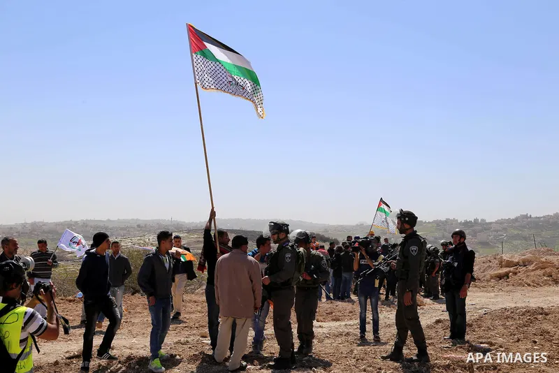 A Palestinian protester argues with an Israeli border policeman as others clear a protest on land that Palestinians say was confiscated by Israel for Jewish settlements, near the West Bank town of Abu Dis near Jerusalem...