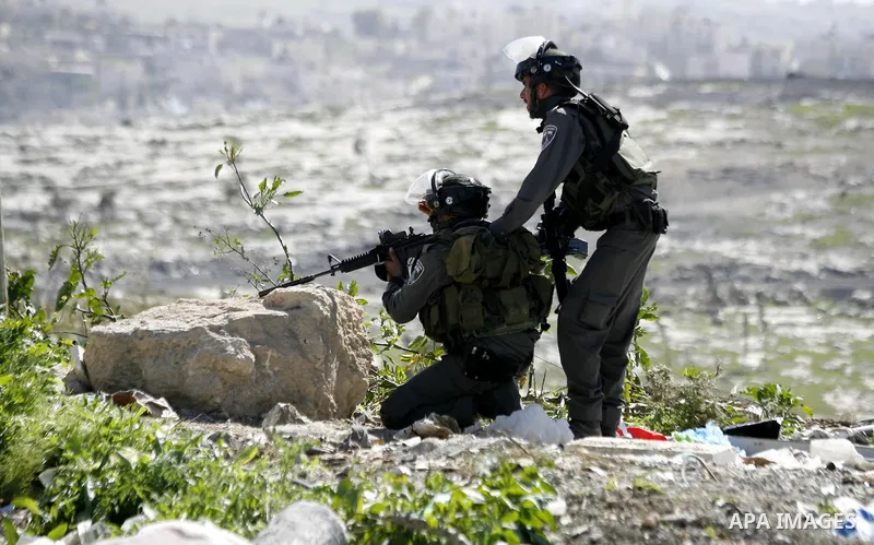 An Israeli border policeman aims at Palestinian protesters during clashes after clear a protest on land that Palestinians say was confiscated by Israel for Jewish settlements, near the West Bank town of Abu Dis near Jeru...