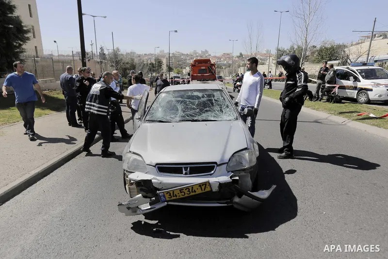 Israeli forensic police inspect a car that ploughed into pedestrians in Jerusalem injuring several people, before its driver got out and tried to stab them, in an attack mirroring similar incidents last year, on March 6,...