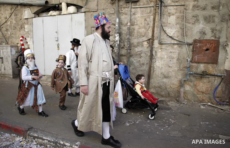 Ultra-Orthodox Jews dressed in costumes as they walk on a sidewalk during celebrations marking the Jewish holiday of Purim in Jerusalem's Mea Shearim neighbourhood March 6, 2015. Purim is a celebration of the Jews' salva...