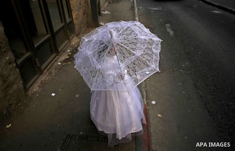 An ultra-Orthodox Jewish girl dressed as a bride stands on a sidewalk during celebrations marking the Jewish holiday of Purim in Jerusalem's Mea Shearim neighbourhood March 6, 2015. Purim is a celebration of the Jews' sa...
