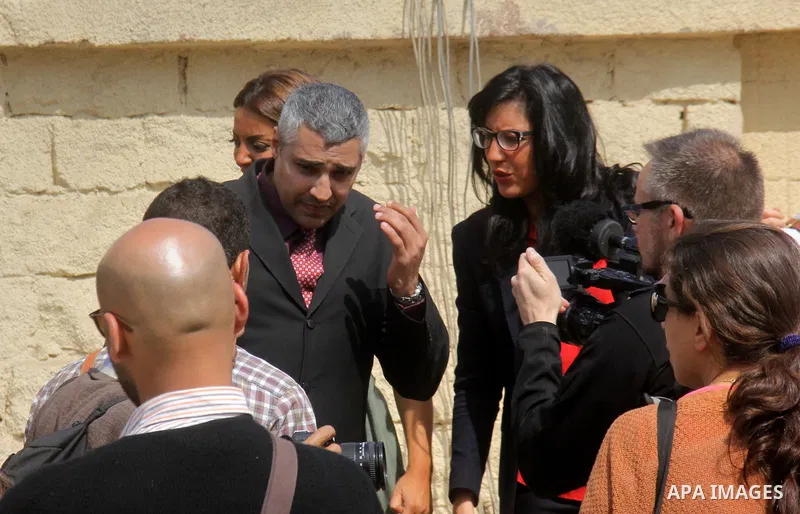 Egyptian journalist Mohamed Fahmy speaks to media during the trial of the Marriott terror cell case in Cairo on March 8, 2015. The court adjourned the retrial of two Al-Jazeera journalists, including Fahmy, freed on bail...