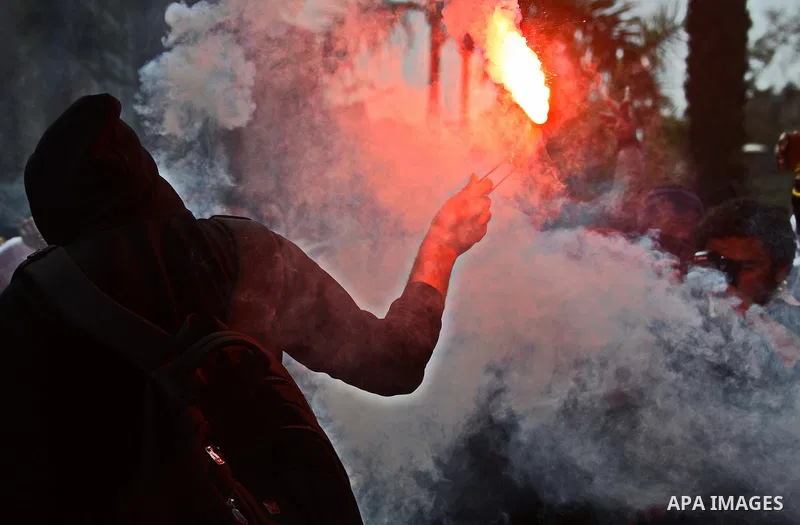An Egyptian student who is support ousted President Mohamed Morsi and the Muslim Brotherhood light up flares as he takes part a protest against the military rule, in Cairo University on March 8, 2015. Photo by Amr Sayed