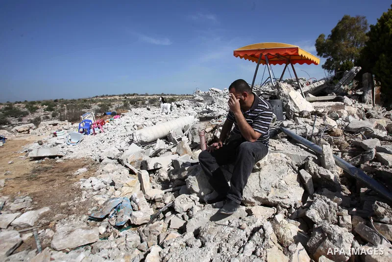 A Palestinian man inspects the remains of the rubble of his house, that was demolished by the Israeli army, near Israel's controversial barrier in the village of Jarushiyya near the west bank city of Tulkarm March 9, 201...