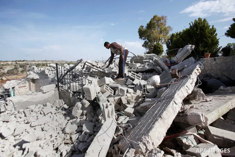 A Palestinian man inspects the remains of the rubble of his house, that was demolished by the Israeli army, near Israel's controversial barrier in the village of Jarushiyya near the west bank city of Tulkarm March 9, 201...