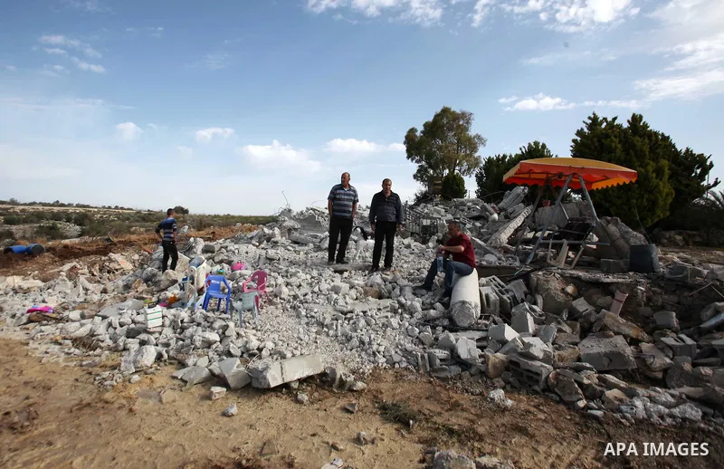 A Palestinian man inspects the remains of the rubble of his house, that was demolished by the Israeli army, near Israel's controversial barrier in the village of Jarushiyya near the west bank city of Tulkarm March 9, 201...
