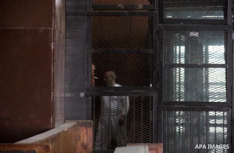 Egyptian defendants are seen behind bars during their trial, in a case known in media as "Rabaa Operation Room", in Cairo on March 9, 2015. The prosecution accused the defendants of several charges relating to preparatio...