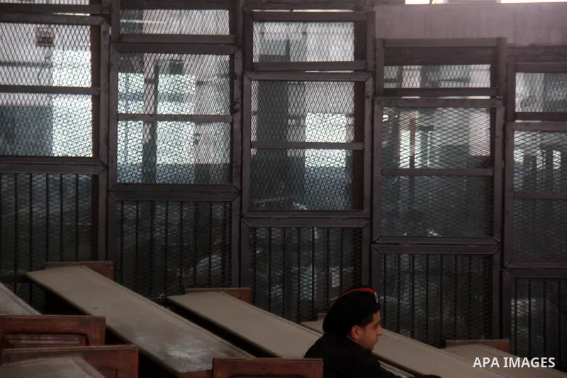 Egyptian defendants are seen behind bars during their trial, in a case known in media as "Rabaa Operation Room", in Cairo on March 9, 2015. The prosecution accused the defendants of several charges relating to preparatio...