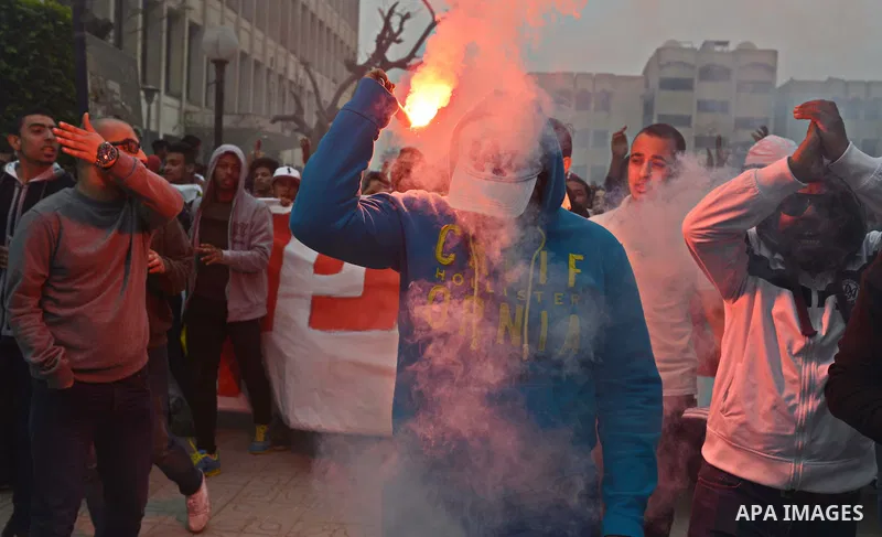 Al-Zamalek soccer club fans known as 'Ultras White Knights" light flares and shout slogans during a protest against interior ministry after the riot that killed more than 20 soccer fans last month, at Cairo University on...