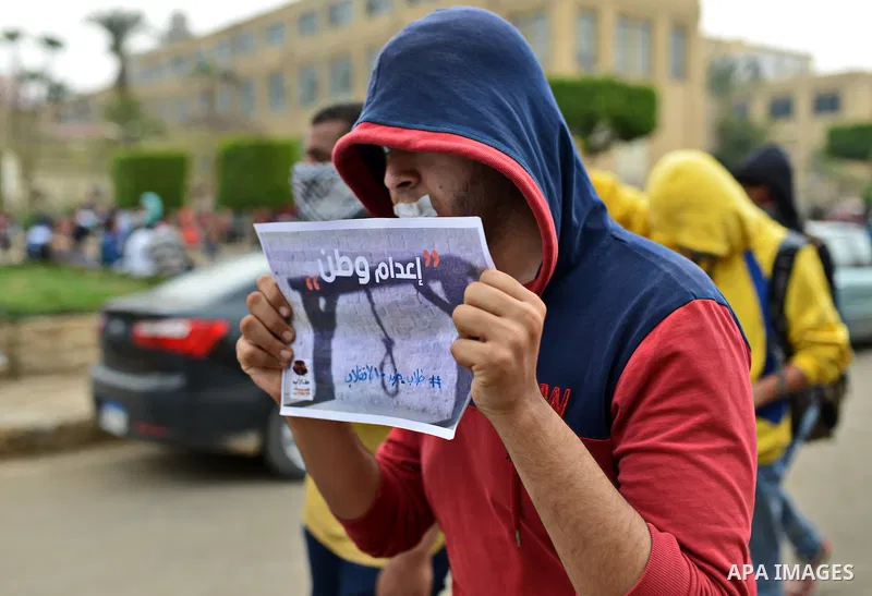 An Egyptian student who support Muslim Brotherhood and ousted president Mohammed Morsi, holds a picture of his fellow during a demonstration against military rule, at Cairo University, in Cairo, March 10, 2015. Photo by...