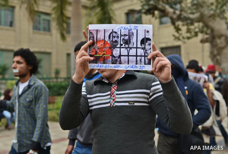 An Egyptian student who support Muslim Brotherhood and ousted president Mohammed Morsi, holds a picture of his fellow during a demonstration against military rule, at Cairo University, in Cairo, March 10, 2015. Photo by...