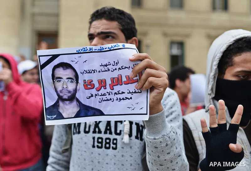 An Egyptian student who support Muslim Brotherhood and ousted president Mohammed Morsi, holds a picture of his fellow during a demonstration against military rule, at Cairo University, in Cairo, March 10, 2015. Photo by...
