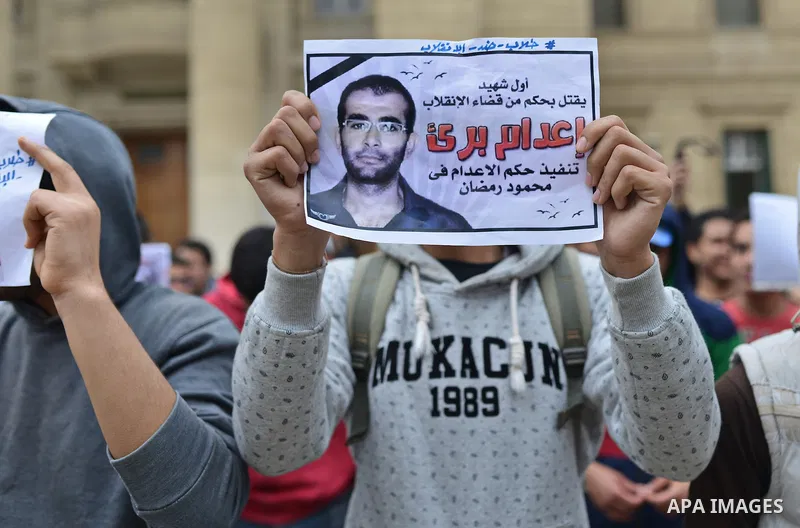 An Egyptian student who support Muslim Brotherhood and ousted president Mohammed Morsi, holds a picture of his fellow during a demonstration against military rule, at Cairo University, in Cairo, March 10, 2015. Photo by...