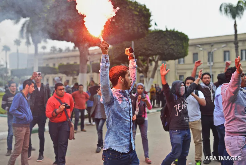 An Egyptian student who is support ousted President Mohamed Morsi and the Muslim Brotherhood light up flares during a demonstration against military rule, at Cairo University, in Cairo, March 10, 2015. Photo by Amr Sayed