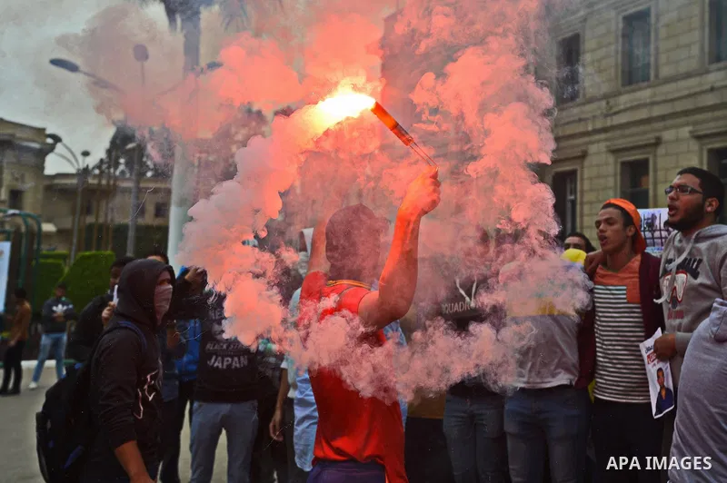 An Egyptian student who is support ousted President Mohamed Morsi and the Muslim Brotherhood light up flares during a demonstration against military rule, at Cairo University, in Cairo, March 10, 2015. Photo by Amr Sayed