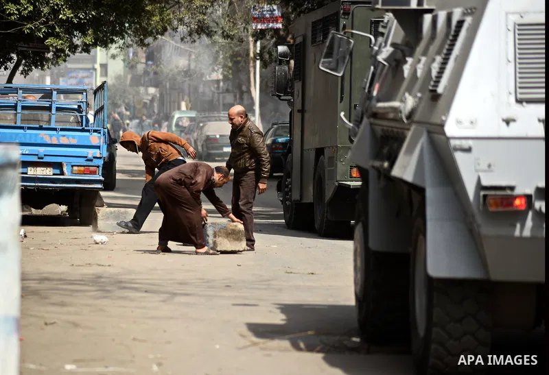 Egyptians stand next to armored vehicles during a demonstration organised by supporters of Muslim Brotherhood and ousted President Mohammed Morsi, against military rule, in the Cairo suburb of Matariya, on March 13, 2015...